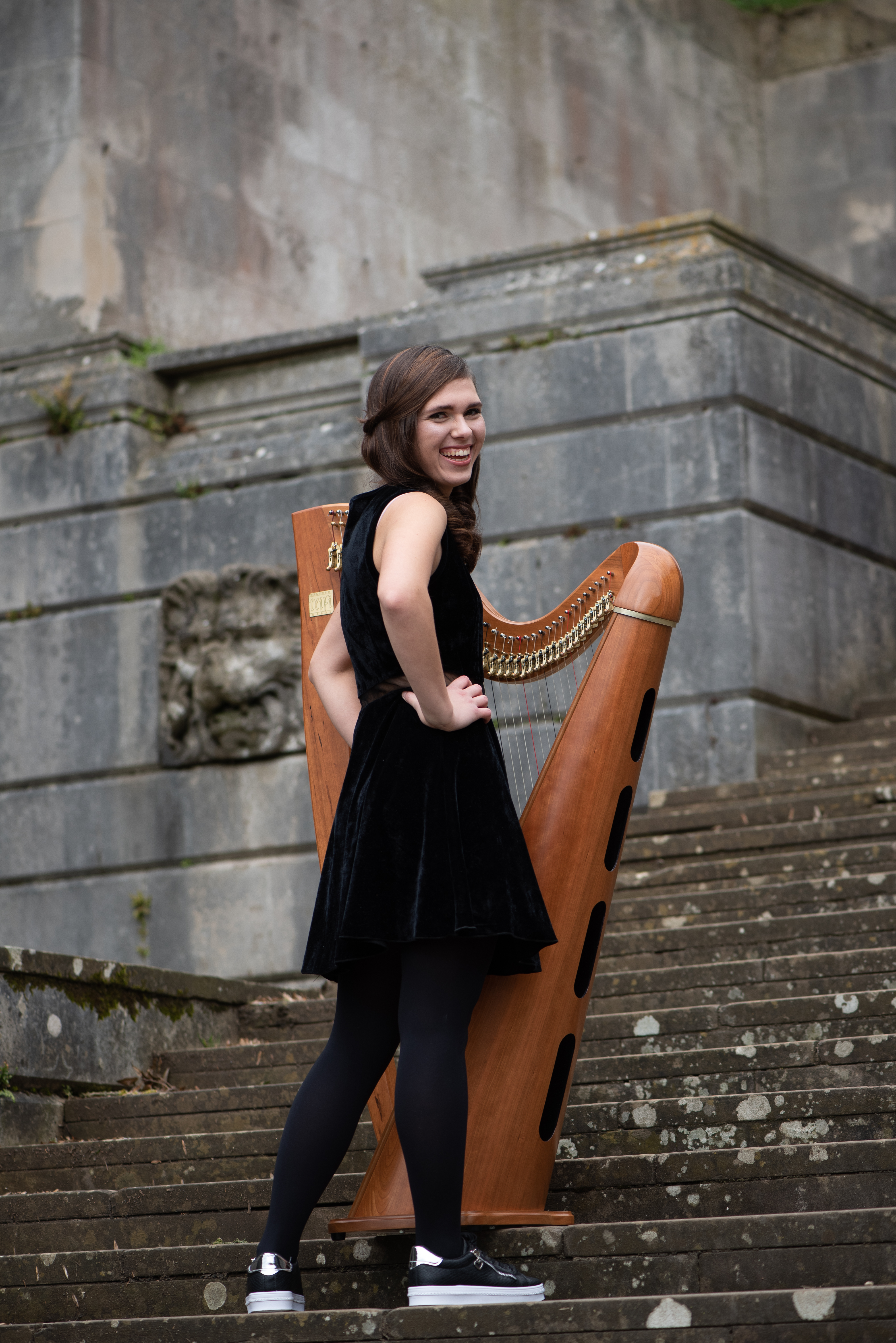 Adel, wedding harpist standing in front of harp