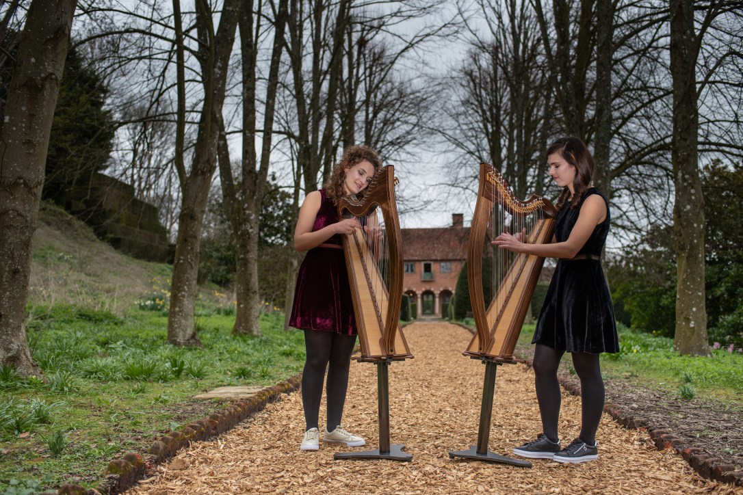 2 of Harps, two harpists playing two small harps on stands outside Port Lympne Hotel and Reserve in Kent