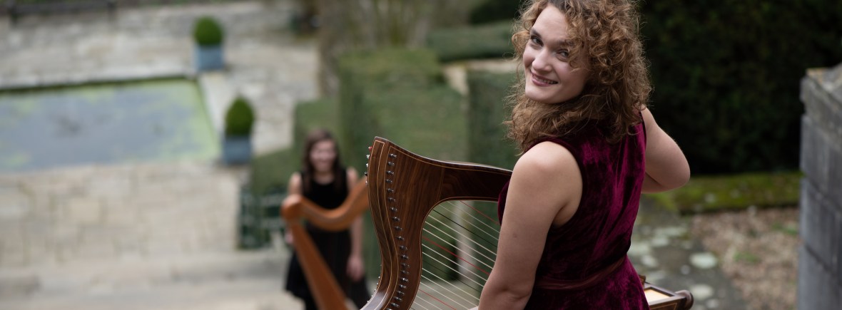 Wedding harpist standing on roman steps at Port Lympne Hotel and reserve, below is second musician with large harp