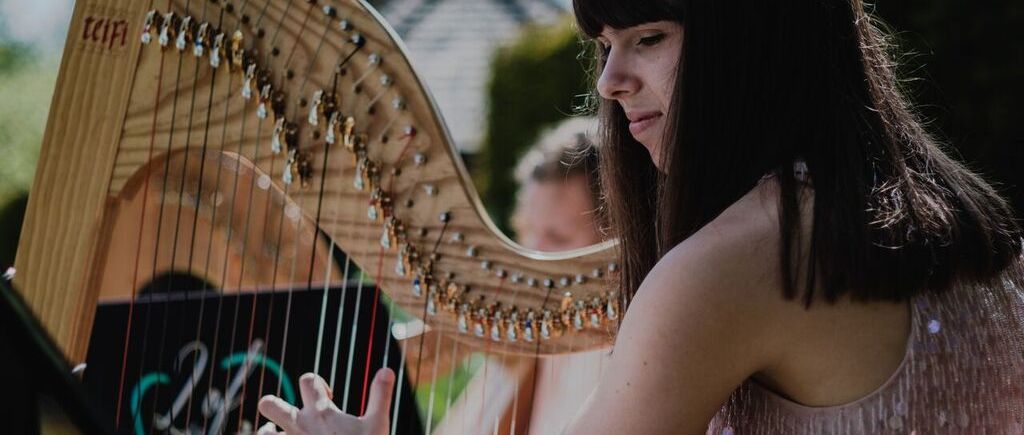 Close up of harpist performing at outdoor wedding ceremony, Swarling Manor Kent, 2 of Harps