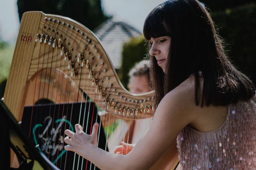 Close up of harpist performing at outdoor wedding ceremony, Swarling Manor Kent, 2 of Harps