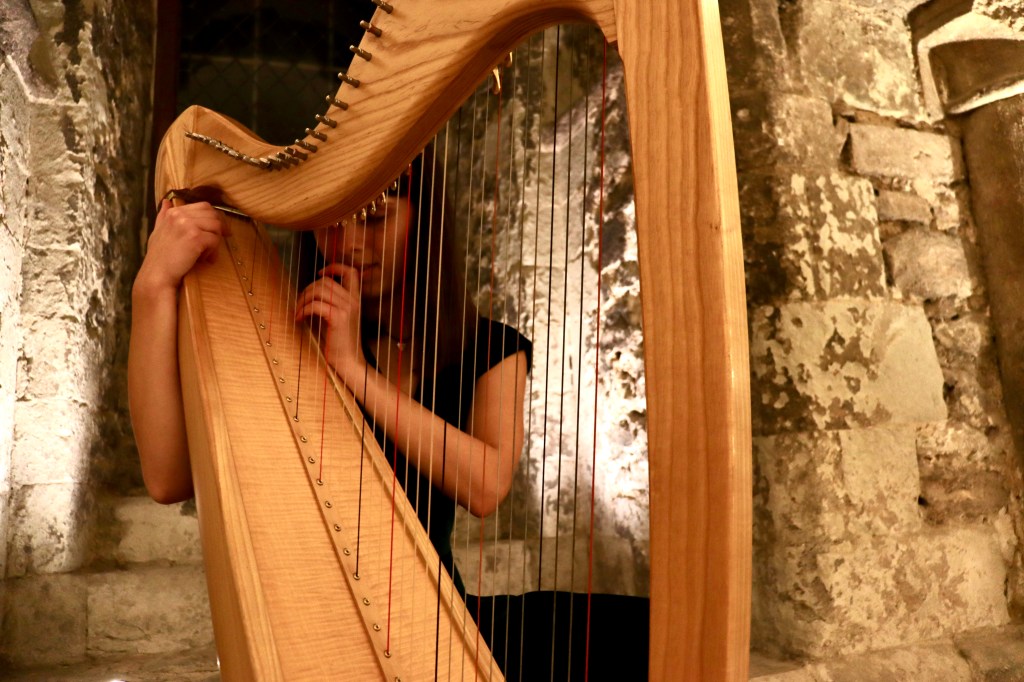wedding harpist close to the harp, in historic cathedral